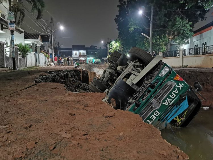 Truk proyek pelebaran kali terguling di Pamulang. (PHD)