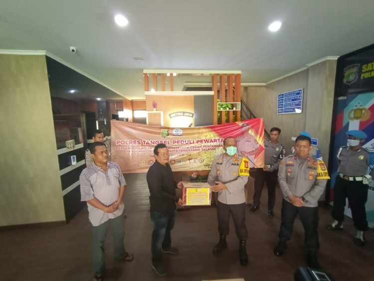 AKBP Iman Setiawan didampingi Waka Polres Tangsel, Kompol Stephanus Luckyto menyerahkan bantuan kepada Ketua Pokja Wartawan Harian Tangsel, Ahmad Rizky Suhaedi di Mapolres Tangsel, Sabtu (4/4/2020).