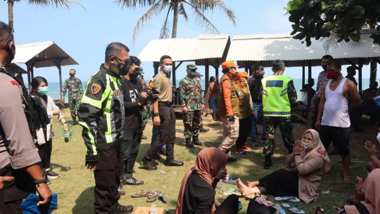 Pendidikan ugas dari Polda Banten meminta masyarakat kembali ke rumah tengah berwisata di Pantai Anyer. (RLS)