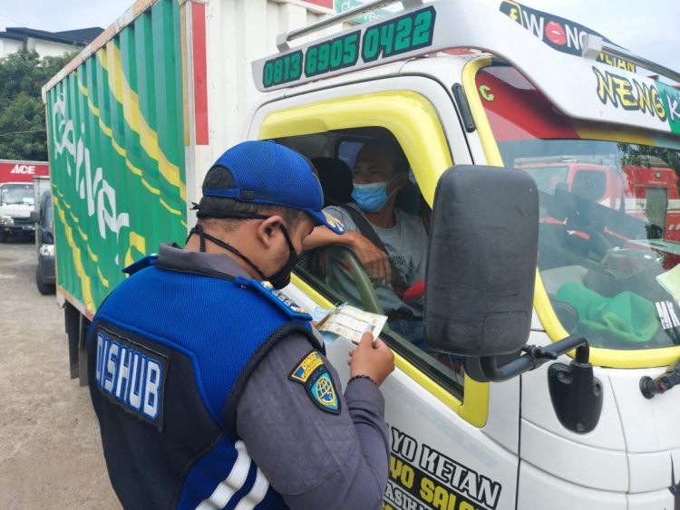 Petugas Dishub Kabupaten Tangerang mengecek kelengkapan surat kendaraan saat razia di Kelapa Dua. (RIK)