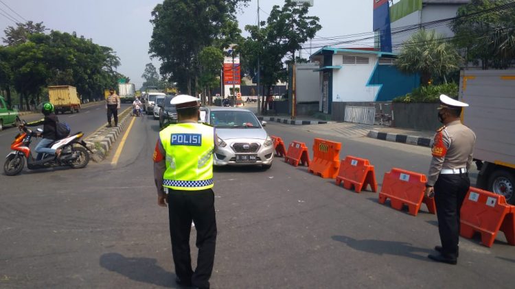 Anggota POlrestro Tangerang Kota memutar balik kendaraan di Jalan Daan Mogot. (KEY)