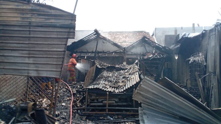 Petugas Damkar Kota Tangerang memadamkan api yang melumat tiga kios di Cipondoh. (SOL)