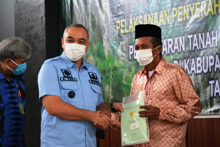 Bupati Tangerang Zaki Iskandar menyerahkan sertipikat tanah ke warga di Tigaraksa. (RIK)