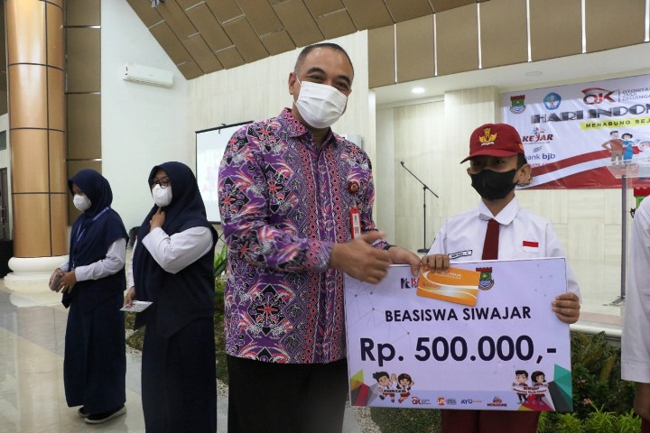 Bupati Tangerang Zaki Iskandar menyerahkan santunan dan beasiswa untuk anak yatim piatu. (RIK)