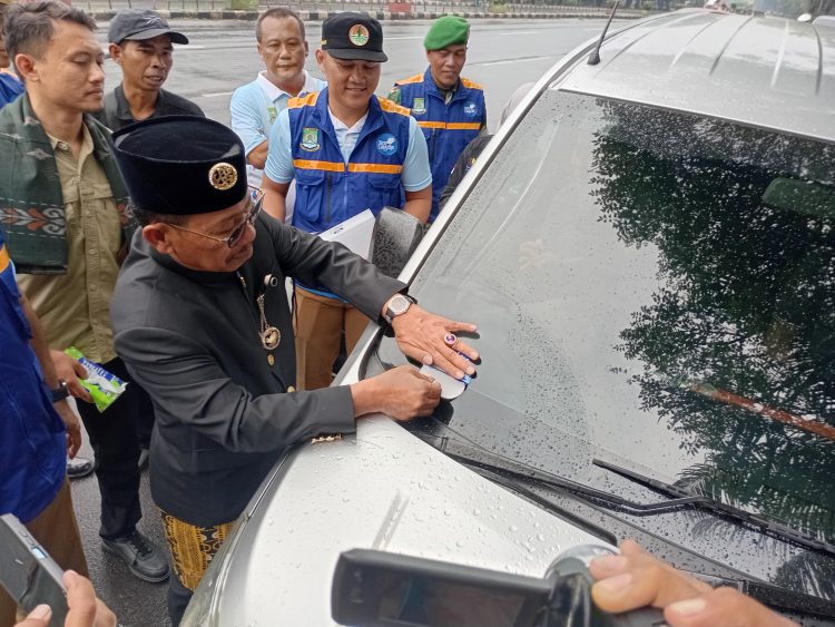 Walikota Tangerang, Sachrudin mnempelkan stiker mobil lolos uji emisi. (KEY)
